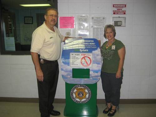 Sheriff Richard Hill and Kim King, MS, Health Educator at Stone County Health Department displaying one of the permanent drug drop boxes.